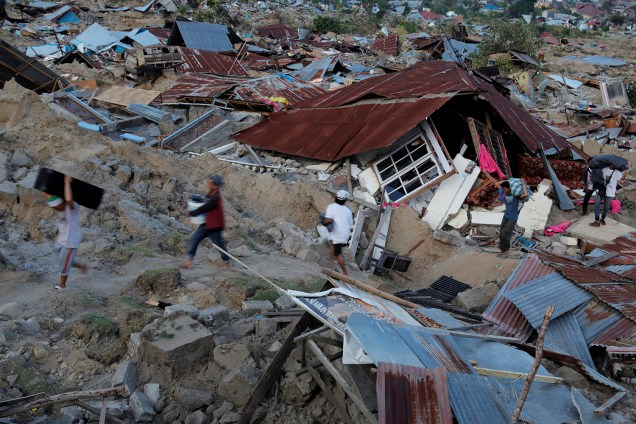 Residentes evacuam suas casas destruídas após o terremoto seguido de tsunami que afetou 1,5 milhão de pessoas na Indonésia - 01/10/2018