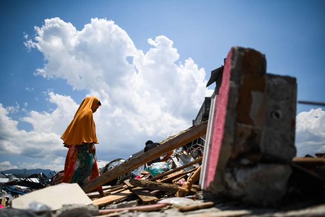Sobrevivente do terremoto caminha sobre os escombros de um complexo fabril em Palu, na Indonésia após o local ser destruído por um terremoto seguido de tsunami - 03/10/2018