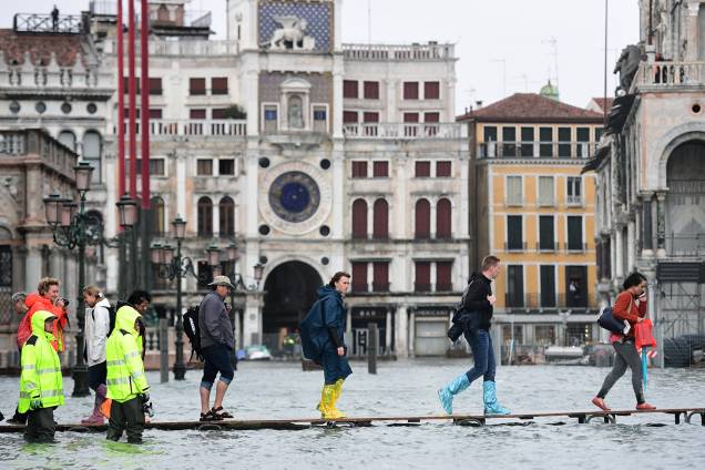 Pessoas andam por uma ponte improvisada na Praça de São Marcos, em Veneza, Itália, após uma inundação devido à alta de 150 centímetros da maré - 29/10/2018