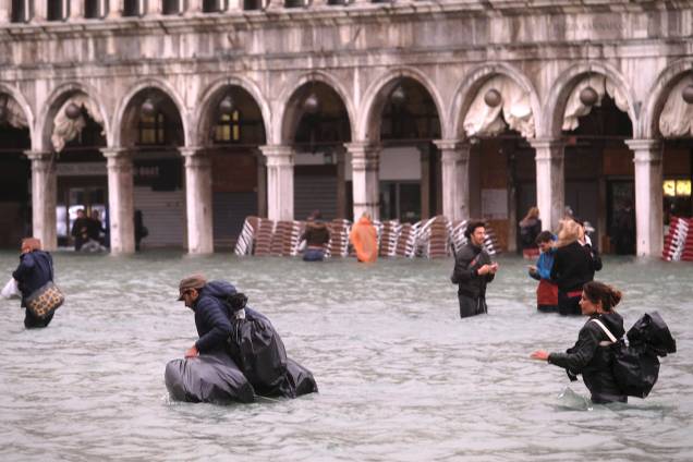 Pessoas caminham na inundada Praça de Marcos, em Veneza, na Itália - 29/10/2018