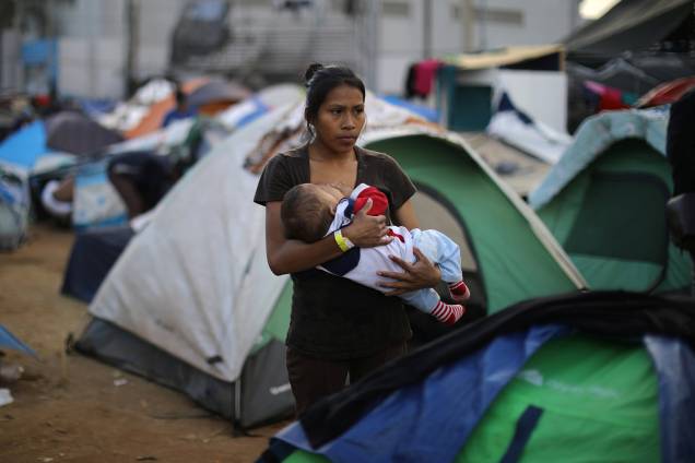 Jessica Perez, 18 anos, segura bebê em acampamento montado na fronteira entre o México e os Estados Unidos, na cidade de Tijuana - 28/11/2018 Jessica Perez, 18 anos, segura bebê em acampamento montado na fronteira entre o México e os Estados Unidos, na cidade de Tijuana - 28/11/2018