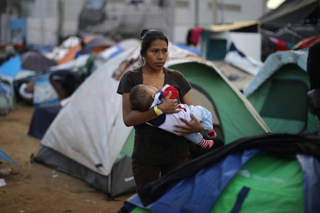 Jessica Perez, 18 anos, segura bebê em acampamento montado na fronteira entre o México e os Estados Unidos, na cidade de Tijuana - 28/11/2018