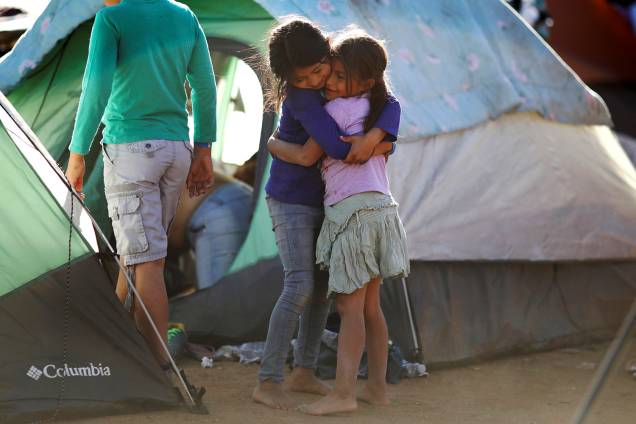 As crianças Vanessa e Seydi, de 7 anos de idade, se abraçam em acampamento improvisado montado por membros da caravana de imigrantes da América Central, próximo da fronteira entre o México e os Estados Unidos, na cidade de Tijuana - 27/11/2018