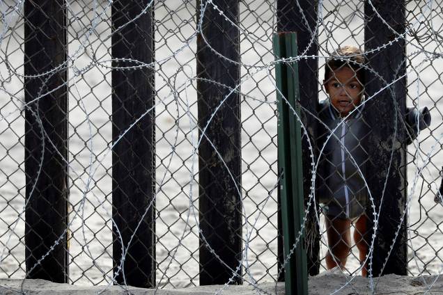 Criança observa através da fronteira entre o México e os Estados Unidos, em San Diego, no estado americano da Califórnia - 28/11/2018