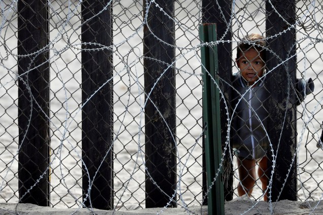 Criança observa através da fronteira entre o México e os Estados Unidos, em San Diego, no estado americano da Califórnia - 28/11/2018
