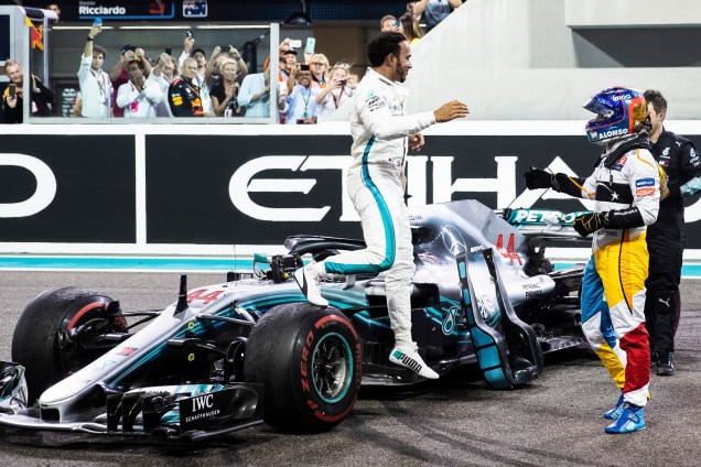 O vencedor da corrida, o britânico Lewis Hamilton da Mercedes comemora com Fernando Alonso da McLaren na despedida do piloto espanhol da F1 após o Grande Prêmio de Abu Dhabi