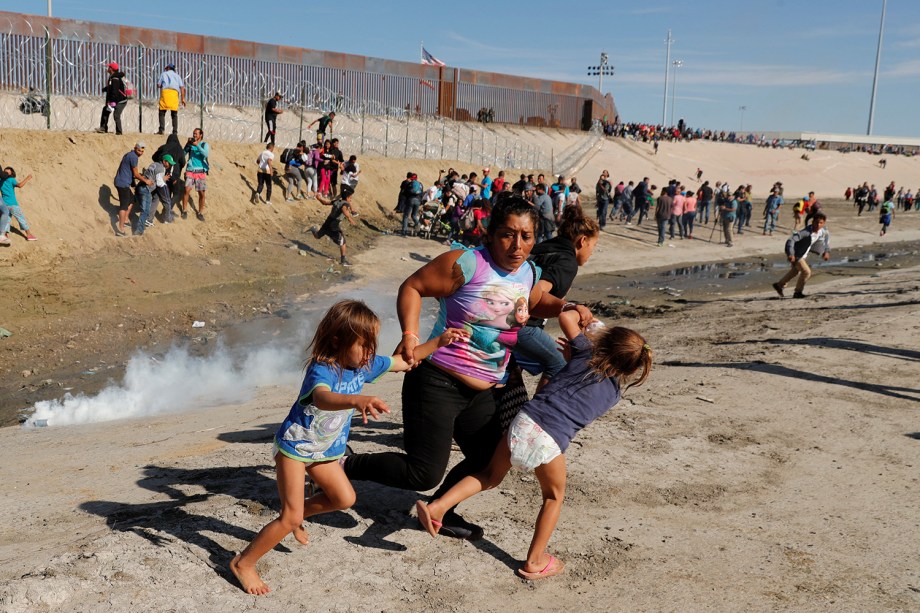 Família de migrantes se dispersam de confronto com policiais, na tentativa de atravessar a fronteira entre o México e os Estados Unidos, na cidade de Tijuana - 25/11/2018