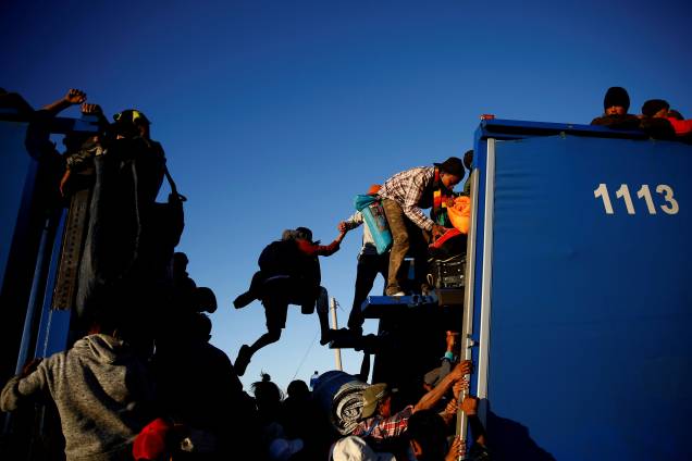 Imigrantes da caravana de milhares de pessoas da América Central que tentam chegar aos Estados Unidos, viajam sobre um caminhão enquanto se dirigem a Tijuana de Mexicali, no México - 20/11/2018
