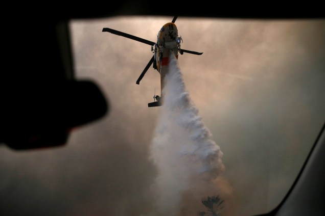 Helicóptero lança água sobre um dos focos do incêndio Woolsey em Malibu, sul Califórnia - 09/11/2018