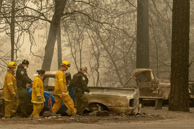 Equipes de resgate retiram um corpo de uma propriedade queimada após ser atingida pelo Camp Fire na área de Holly Hills, na Califórnia - 15/11/2018