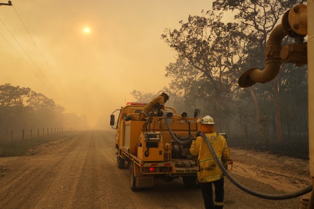 Bombeiros reabastecem um caminhão tanque durante combate a um incêndio florestal em Queensland, na Austrália - 28/11/2018