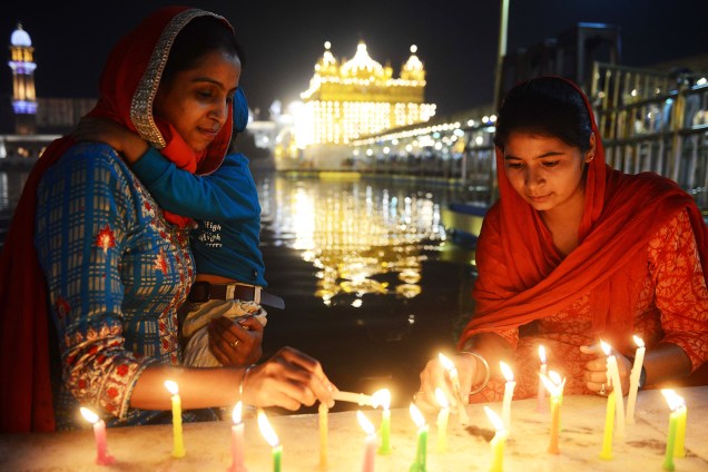 Devotas indianas acendem velas às vésperas do festival Diwali, conhecido como o 'Festival das Luzes',  no Templo Dourado, em Amritsar - 06/11/2018