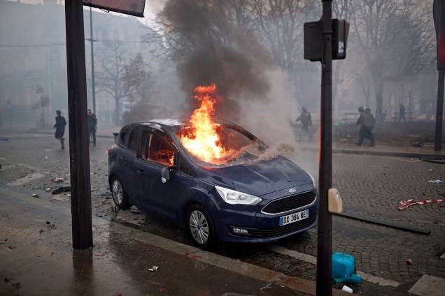 Carro é incendiado durante protesto contra o aumento do imposto sobre combustíveis na Champs Elysees, em Paris, França - 24/11/2018