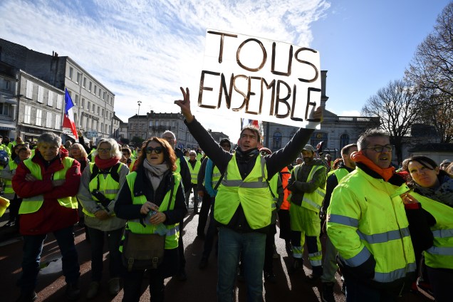 Manifestantes usando coletes amarelos (Gilets jaunes) gritam palavras de ordem e carregam e cartazes durante manifestação contra o aumento no preço dos combustíveis em Rochefort, no sudoeste da França - 24/11/2018