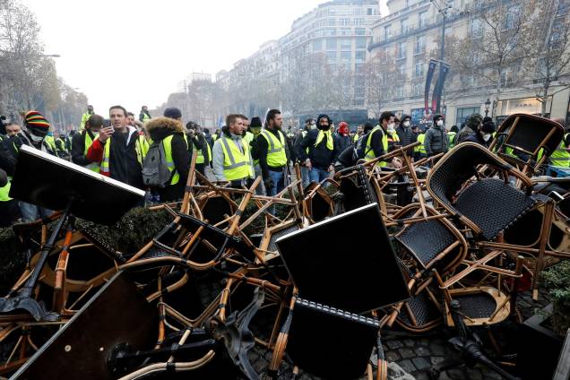 Manifestantes vestidos com coletes amarelos fazem barricadas com cadeiras na Champs Elysees, em Paris durante protesto nacional contra o aumento dos preços do petróleo e dos custos de vida - 24/11/2018