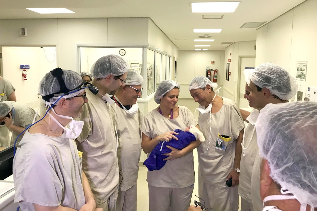Funcionários do Hospital das Clínicas observam a bebê que nasceu de um útero doado de uma brasileira falecida