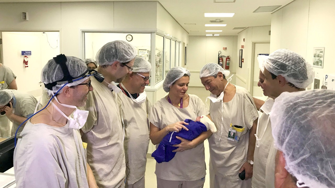 Funcionários do Hospital das Clínicas observam a bebê que nasceu de um útero doado de uma brasileira falecida