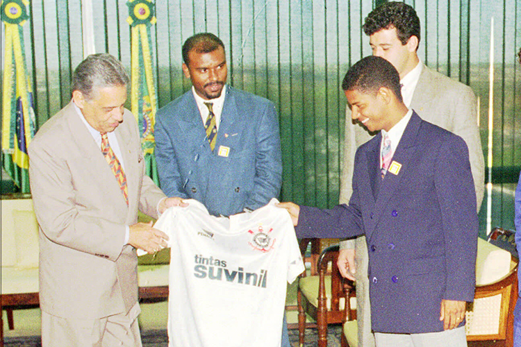 Fernando Henrique Cardoso foi presidente da República por dois mandatos: entre 1995 e 2003. O ex-presidente torce para o clube paulista Corinthians e para o Fluminense. Na foto, recebe de presente uma camisa dos jogadores Marcelinho Carioca, Ronaldo e Célio Silva, durante encontro com jogadores e diretores do time.