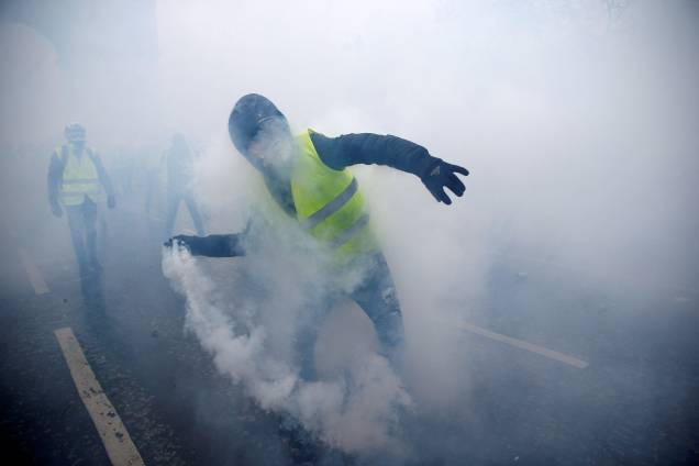 Manifestante é visto com uma bomba de gás lacrimogêneo durante a manifestação contra a alta dos impostos sobre o diesel - 01/12/2018