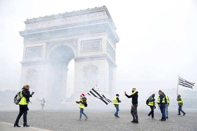 Uma nuvem de gás lacrimogêneo flutua proximo ao Arco do Triunfo, em Paris, enquanto manifestantes protestam contra a alta do preço dos combustíveis - 01/12/2018