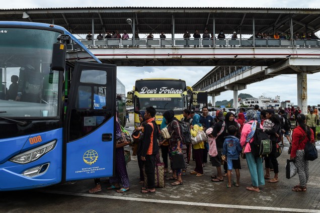 Moradores embarcam em um ônibus no porto de balsas após serem evacuados da Ilha Sebesi, em Bakauheni, província de Lampung, devido ao estrago do tsunami que atingiu a Indonésia - 26/12/2018