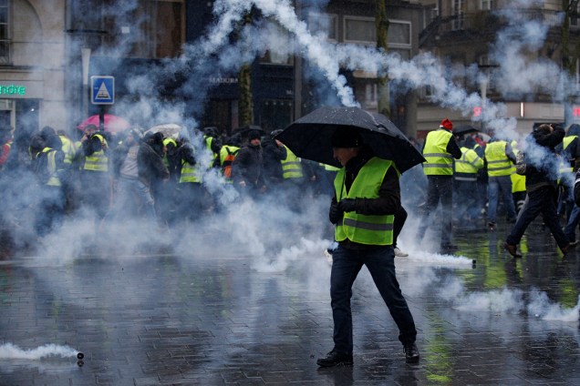 Bombas de gás lacrimogêneo são arremessadas contra manifestantes vestidos com coletes amarelos, durante protesto contra o governo realizado em Nantes, na França - 15/12/2018