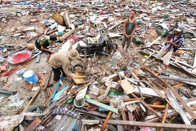 Moradores locais procuram pertences entre destroços após forte tsunami atingir a praia de Tanjung Lesung, localizada na província de Banten - 24/12/2018