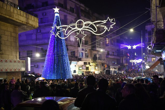 Sírios acompanham o acendimento das luzes de árvore de Natal em praça de Alepo, noroeste do país - 23/12/2018