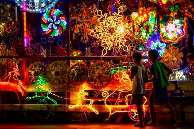 Crianças são vistas próximas de luzes de Natal, em exposição feita em rua de Manila, capital das Filipinas - 24/12/2018