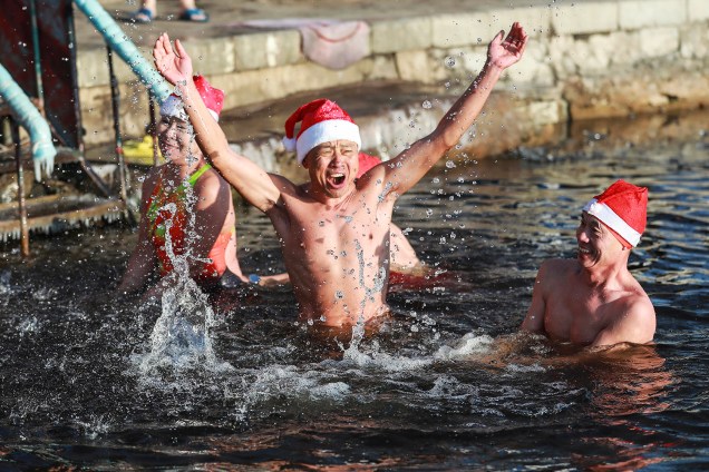Pessoas com gorros nadam em lago congelado, com temperatura que chega a 21 graus negativos, na cidade chinesa de Shenyang, na véspera do Natal - 24/12/2018