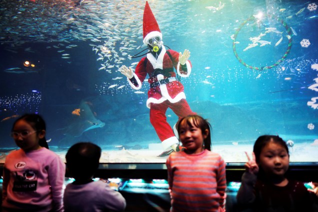 Mergulhador vestido de Papai Noel posa para foto com crianças durante evento promocional de Natal em Seul, na Coreia do Sul - 07/12/2018