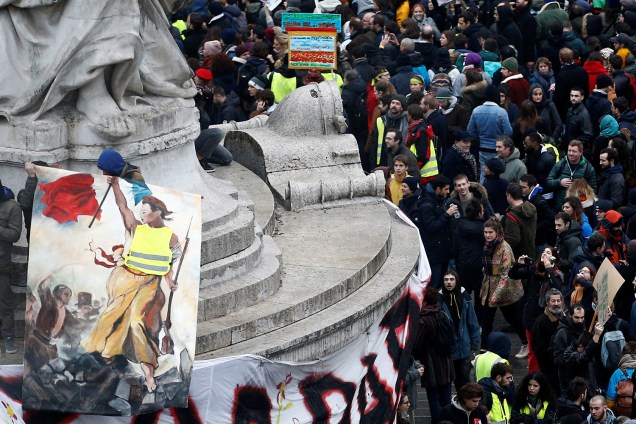 Manifestante segura pintura de Marianne vestindo um colete amarelo na Praça da República em Paris, França - 08/12/2018
