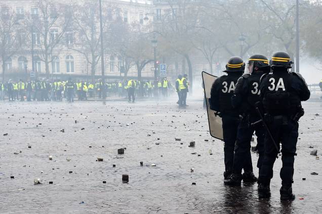 Oficiais da polícia de choque permanecem em posição durante confrontos com manifestantes na  Champs-Elysées em Paris - 01/12/2018