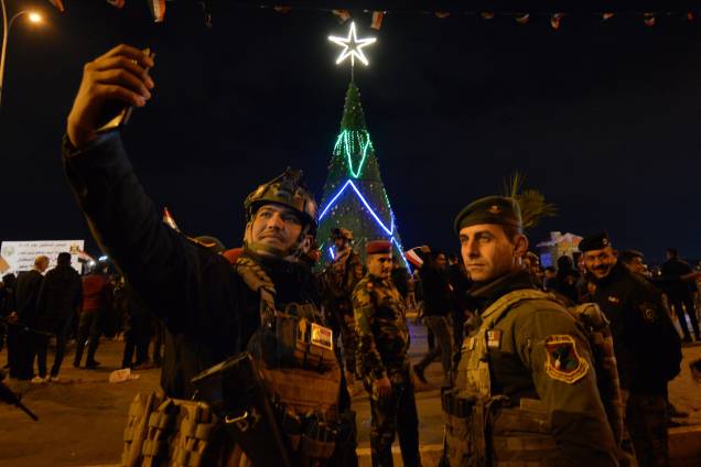Membros das forças de segurança iraquianas tiram uma selfie enquanto as pessoas se reúnem no centro da cidade de Mosul, no norte do país, para celebrar a chegada do ano novo - 31/12/2018 Membros das forças de segurança iraquianas tiram uma selfie enquanto as pessoas se reúnem no centro da cidade de Mosul, no norte do país, para celebrar a chegada do ano novo - 31/12/2018