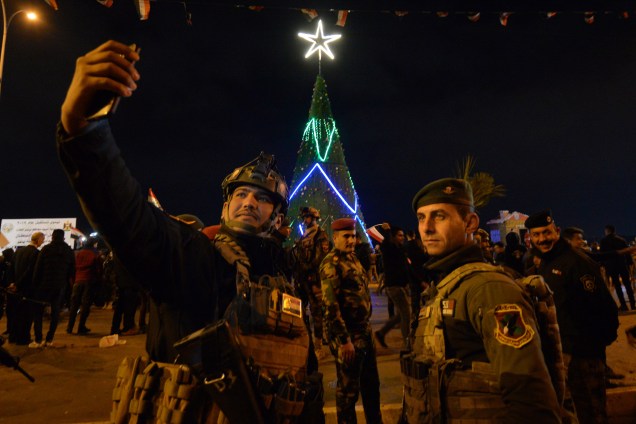 Membros das forças de segurança iraquianas tiram uma selfie enquanto as pessoas se reúnem no centro da cidade de Mosul, no norte do país, para celebrar a chegada do ano novo - 31/12/2018