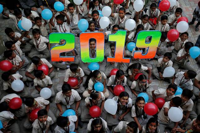 Crianças seguram balões enquanto posam para foto durante as comemorações para receber o Ano Novo em sua escola em Ahmedabad, Índia - 31/12/2018 Crianças seguram balões enquanto posam para foto durante as comemorações para receber o Ano Novo em sua escola em Ahmedabad, Índia - 31/12/2018