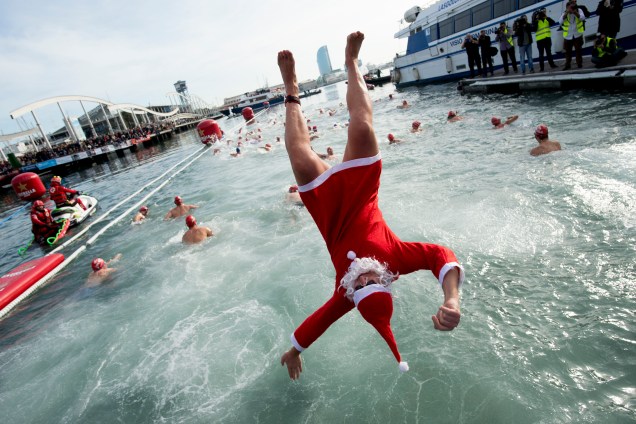 Homem vestido de Papai Noel pula na água durante a 109ª edição da competição de natação 'Copa Nadal' (Copa de Natal) no Port Vell de Barcelona, na Espanha - 25/12/2018