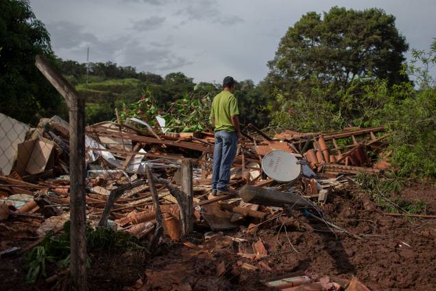Homem caminha sobre os escombros de uma casa na comunidade do Parque da Cachoeira, um dia após o colapso de uma barragem pertencente à mineradora Vale perto da cidade de Brumadinho (MG) - 26/2019