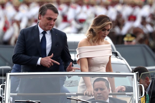 O novo presidente do Brasil, Jair Bolsonaro, gesticula enquanto desfila em carro aberto ao lado da esposa Michelle Bolsonaro antes da cerimônia de posse em Brasília - 01/01/2019