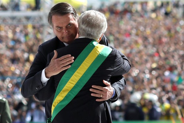 O presidente Jair Bolsonaro recebe a faixa presidencial das mãos do antecessor, Michel Temer, em cerimônia no Palácio do Planalto, em Brasília - 01/01/2019