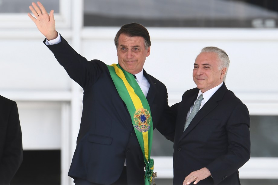 Presidente Jair Bolsonaro recebe a faixa presidencial do ex-presidente Michel Temer após subir a rampa do Palácio do Planalto, em Brasília - 01/01/2019