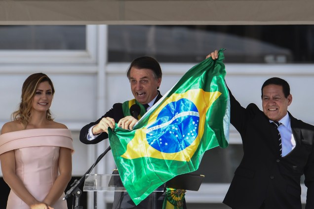 Presidente Jair Bolsonaro o vice-presidente Hamilton Mourão exibem uma bandeira nacional durante discurso no Palácio do Planalto em Brasília - 01/01/2018