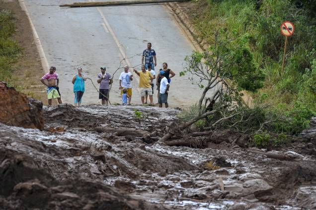 Moradores observam o mar de lama no trecho de uma estrada após o rompimento da barragem da mina do Córrego do Feijão em Brumadinho (MG)