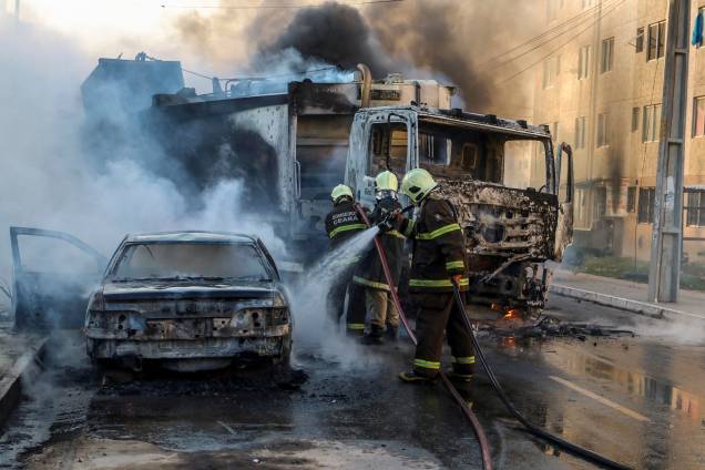Bombeiros apagam as chamas de um caminhão e um carro incendiados durante a onda de violência que atinge o estado do Ceará, no bairro Conjunto Palmeiras, em Fortaleza - 03/01/2019