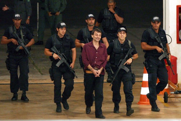 O ex-ativista de extrema esquerda italiano Cesare Battisti, 52, é escoltado por policiais da Polícia Federal ao chegar em Brasília (DF). Battisti foi um dos chefes da organização de extrema esquerda Proletários Armados pelo Comunismo. Os assassinatos pelos quais foi condenado ocorreram em 1978 e 1979. Ele foi preso no Rio de Janeiro, onde estava desde 2004 - 19/03/2007