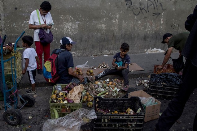 Venezuelanos coletam restos de frutas e vegetais de mercado de rua em Caracas, Venezuela - 18/05/2018