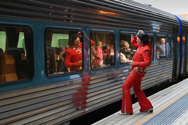Um fã vestido como Elvis Presley, usa a janela do trem como um espelho na estação Central, antes de embarcar para o Parkes Elvis Festival, em Sydney, na Austrália - 10/01/2019
