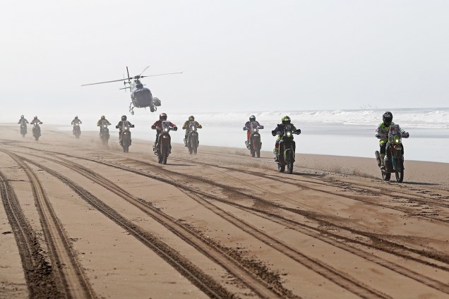 Competidores participam da quinta etapa do Rally Dakar 2019, na praia de Los Palos, entre as cidades peruanas de Moquegua e Arequipa. Ao fundo, helicóptero de TV acompanha os pilotos - 11/01/2019