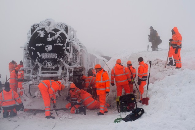 Trabalhadores descongelam uma locomotiva a vapor enquanto tentam liberar um trem comum do trem de bitola estreita Harzer Schmalspurbahn, que ficou preso na neve da montanha de Brocken, na região de Harz, perto de Wernigerode e Schierke, região central da Alemanha - 10/01/2019