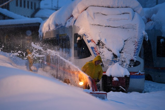 Trabalhador remove a neve ao lado de um trem regional na estação de Berchtesgaden, na Alemanha - 10/01/2019